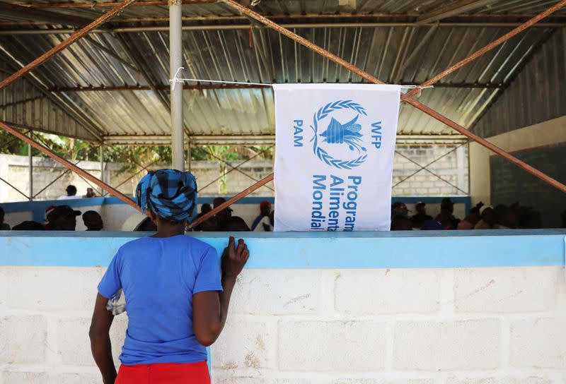 A woman watches as money is distributed by the World Food Programme in Bainet