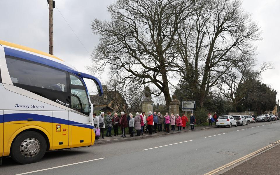 A bus picking up a group of elderly visitors on Station Road, Bourton-on-the-Water