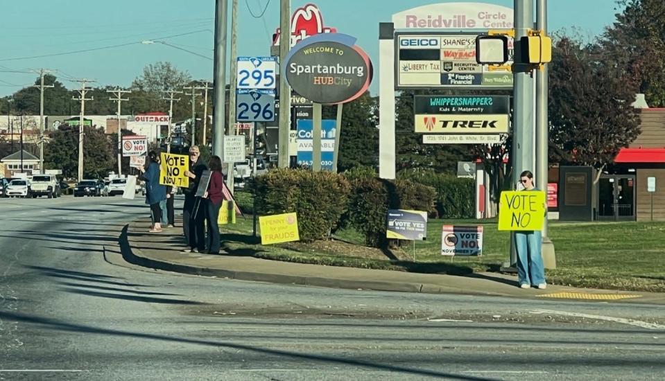 Penny sales tax opponents with signs Friday afternoon, Nov. 3, at John B. White Sr. Boulevard and East Blackstock Road, Spartanburg.