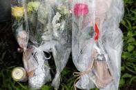 Flowers and a keychain with an image from the "K-On" animation series by Kyoto Animation, are placed near the torched Kyoto Animation building to mourn the victims of the arson attack, in Kyoto