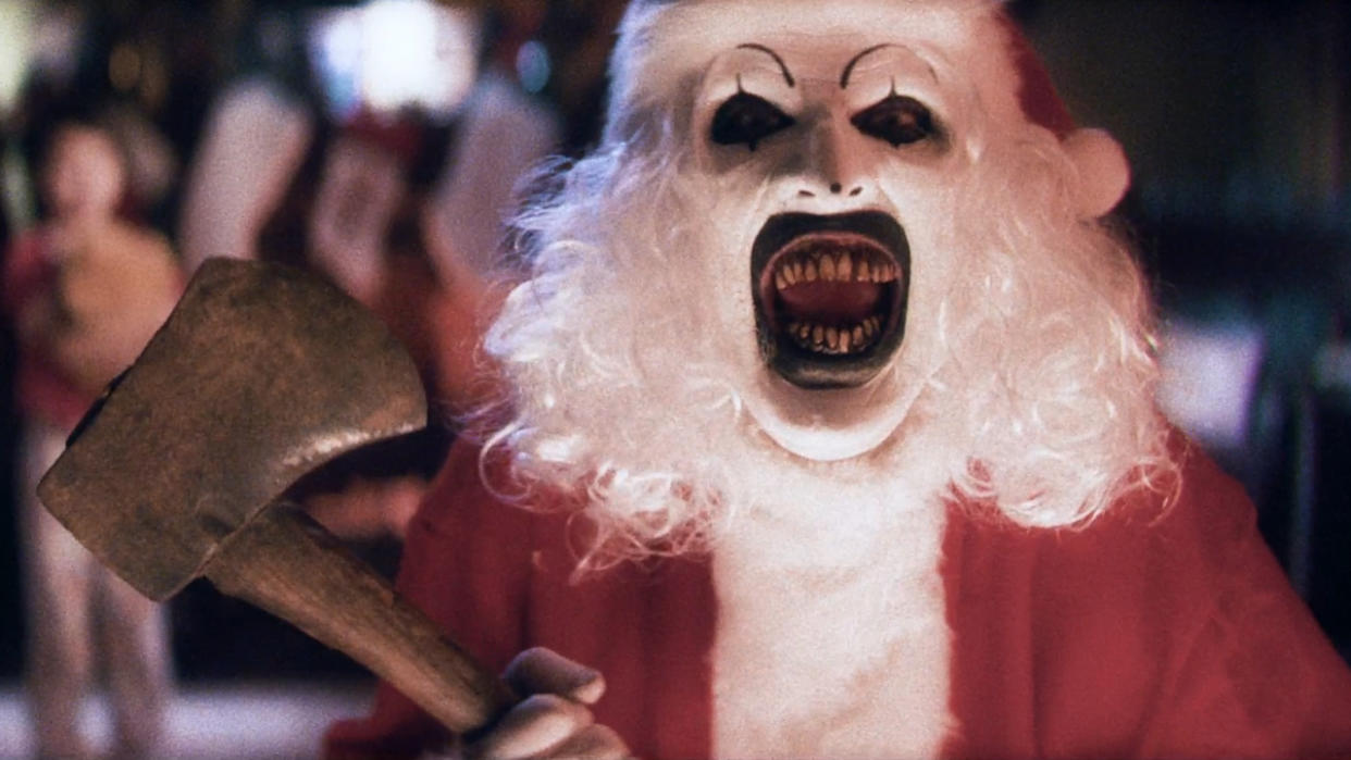  David Howard Thorton as Art the Clown, laughing while dressed as Santa with an axe, in Terrifier 3. 