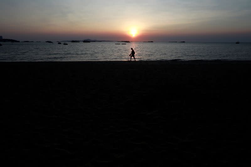 Man walks on almost empty beach in Pattaya