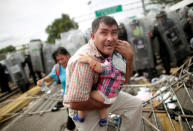 A Honduran migrant protects his child after fellow migrants, part of a caravan trying to reach the U.S., stormed a border checkpoint in Guatemala, in Ciudad Hidalgo, Mexico October 19, 2018. REUTERS/Ueslei Marcelino