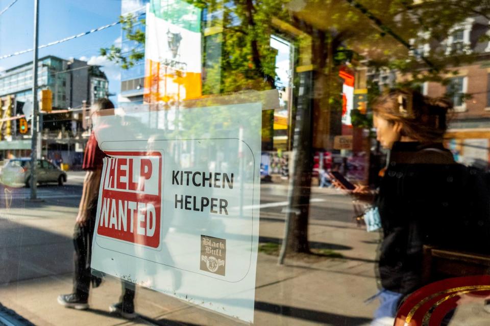 A help wanted sign hangs in a bar window along Queen Street West in Toronto Ontario, Canada June 10, 2022. REUTERS/Carlos Osorio