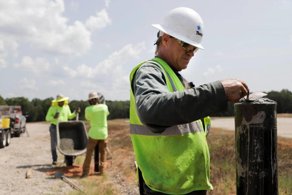 Charlotte-based Albemarle Corp. is moving closer to reopening a lithium mine and production in Kings Mountain. Shown, Tom Frederick smooths out the top of a gate post on the future site of Albemarle Corp.’s $1.3 billion facility in Chester County, S.C.