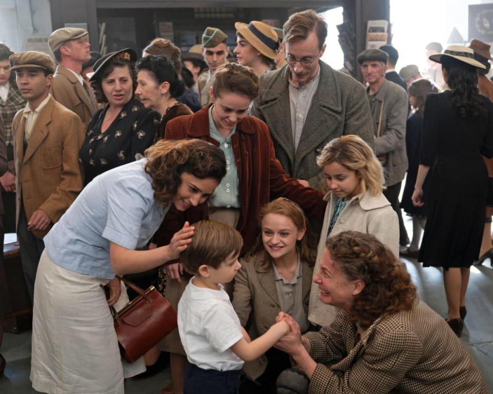 The cast of ‘We Were the Lucky Ones’ hug in a still from ‘We Were the Lucky Ones’