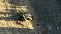 Emergency responders investigate the scene of a crash, Thursday, Feb. 22, 2024 on U.S. 287 about 10 miles (16 kilometers) south of the Wyoming-Colorado line between Laramie and Fort Collins, Colo. Three members of the University of Wyoming swimming and diving team were killed in the crash. (KMGH Denver7 via AP)