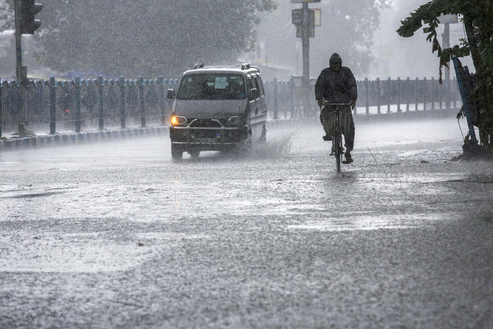 A man pedals through heavy rain under the inclement weather due to Cyclone Yaas in Kolkata, India, Wednesday, May 26, 2021. Heavy rain and a high tide lashed parts of India's eastern coast as a cyclone pushed ashore Wednesday in an area where more than 1.1 million people have evacuated amid a devastating coronavirus surge. (AP Photo/Bikas Das)