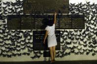 <p>A woman touches a memorial plate as she participates in a protest in commemoration of women murdered in El Salvador as part of the celebration of International Women’s Day in San Salvador on March 8, 2018. (Photo: Marvin Recinos/AFP/Getty Images) </p>