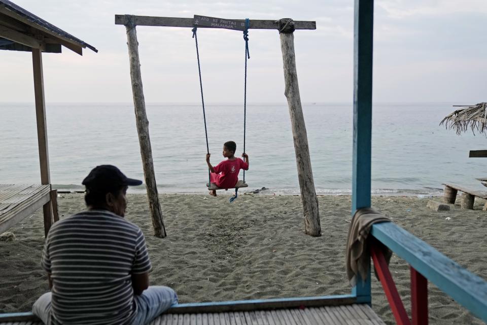 A boy plays on a swing on a beach where maleos are known to lay their eggs, in Mamuju, West Sulawesi, Indonesia, Saturday, Oct. 28, 2023. With their habitat dwindling and nesting grounds facing encroachment from human activities, maleo populations have declined by more than 80% since 1980, an expert said.(AP Photo/Dita Alangkara)