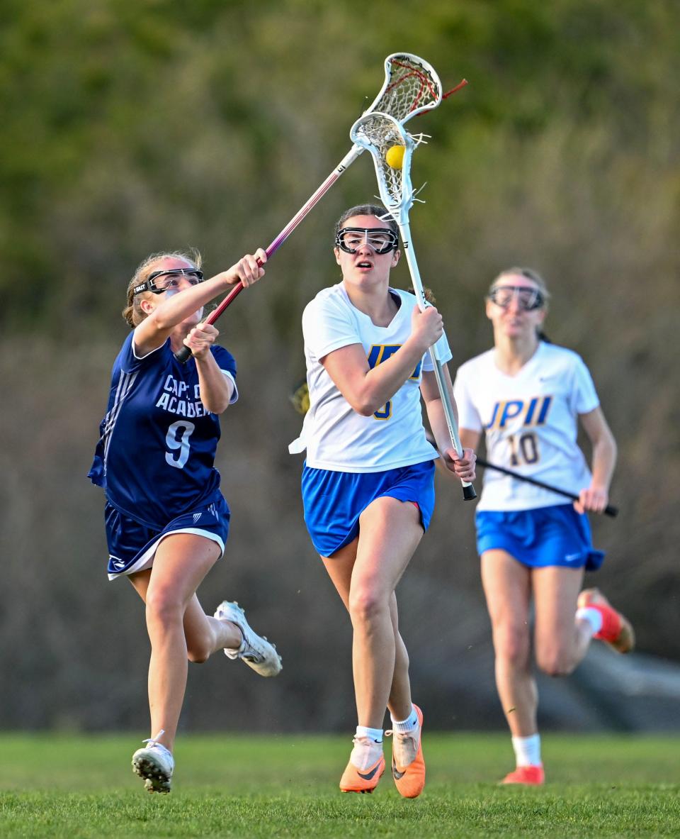 SANDWICH 04/16/24 Quinn Powers of Cape Cod Academy attempts to know the ball loose from Katelyn Lawson of St. John Paul II.