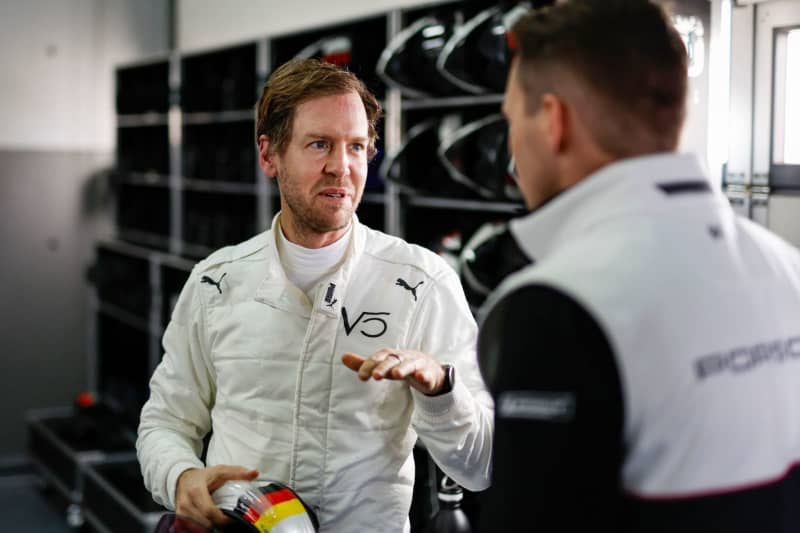 German motorsports racing driver Sebastian Vettel (L) speaksw with a Porsche employee. Four-time Formula One world champion Sebastian Vettel tested for Porsche on Tuesday in Spain as the German carmaker gears up for the Le Mans 24-hour. Porsche Handout/dpa