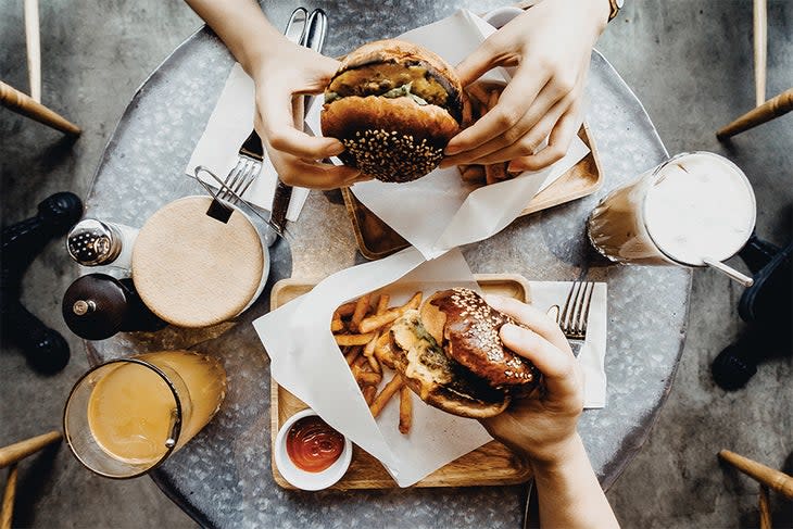 Two people eating burgers