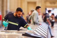 FILE PHOTO: A Trenes Argentinos (Argentinian Trains) employee cleans ticket machines as a protective measure against the outbreak of the coronavirus disease (COVID-19), in Buenos Aires