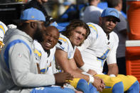 Los Angeles Chargers quarterbacks Justin Herbert, center, and Chase Daniel, right, sit on the bench with teammates during the second half of an NFL football game against the Baltimore Ravens, Sunday, Oct. 17, 2021, in Baltimore. The Ravens won 34-6. (AP Photo/Gail Burton)