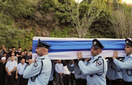 Israeli police officers carry the flag draped coffin of Druze police officer Kamil Shanan during his funeral in the village of Hurfeish, Israel July 14 2017. REUTERS/Ammar Awad