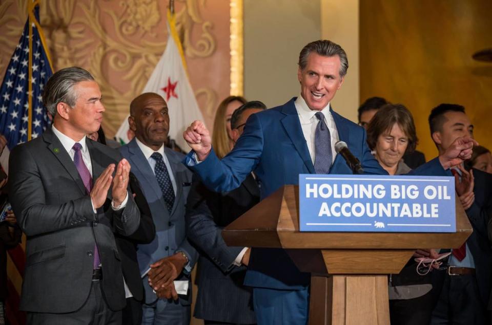 Gov. Gavin Newsom is surrounded by legislators and state officials — including state Attorney General Rob Bonta, left, and state Sen. Nancy Skinner, D-Berkeley, right — as he speaks before signing a bill at the Capitol on Tuesday, March 28, 2023, aimed at addressing gas price gouging.