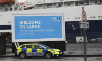 Police patrol the port of Larne, Northern Ireland, Tuesday, Feb. 2, 2021. Authorities in Northern Ireland have suspended checks on animal products and withdrawn workers from two ports after threats against border staff. (AP Photo/Peter Morrison)