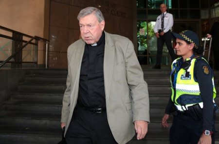 Vatican treasurer Cardinal George Pell is watched by a security guard and an Australian police officer as he leaves Melbourne Magistrates' Court in Australia, March 19, 2018.    AAP/Stefan Postles/via REUTERS