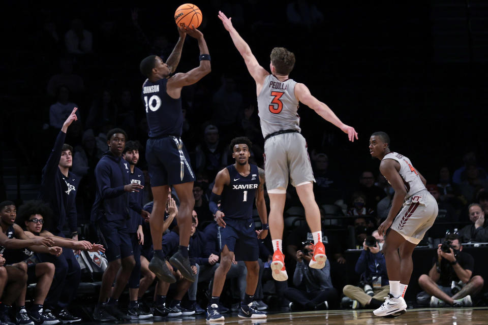 Xavier's Nate Johnson (10) shoots a 3-point basket in front of Virginia Tech's Sean Pedulla (3) in the final seconds of an NCAA college basketball game in the NIT Season Tip-Off tournament Friday, Nov. 26, 2021, in New York. Xavier won 59-58. (AP Photo/Adam Hunger)