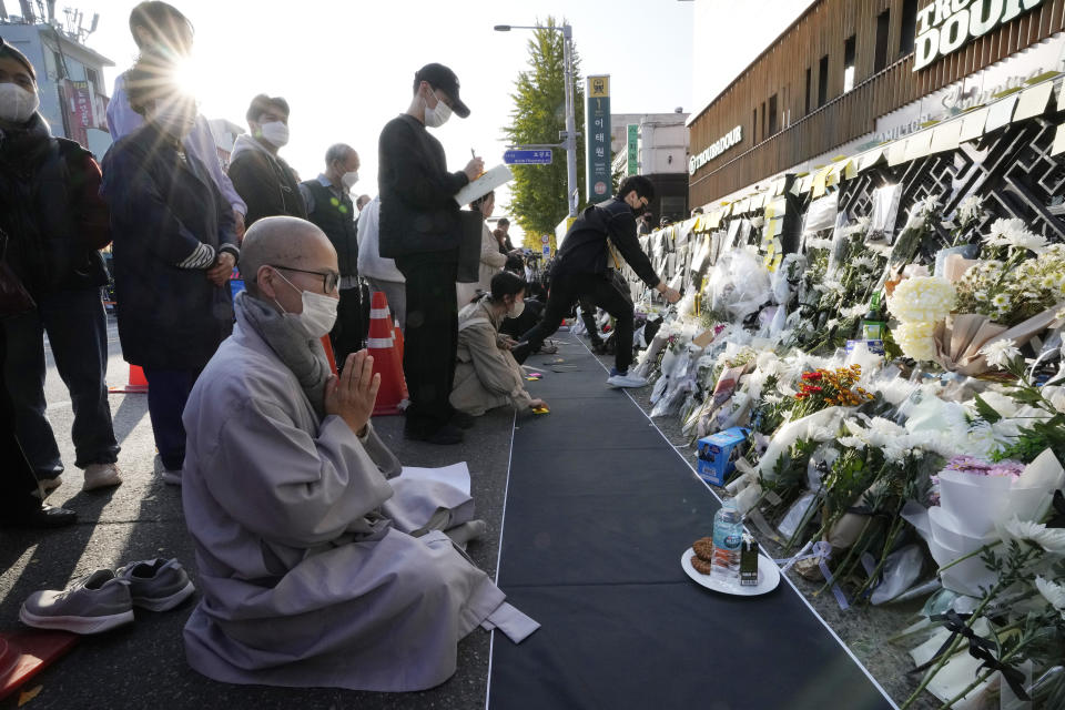 A Buddhist monk prays for victims of a deadly accident following Saturday night's Halloween festivities on the street near the scene in Seoul, South Korea, Tuesday, Nov. 1, 2022. (AP Photo/Ahn Young-joon)