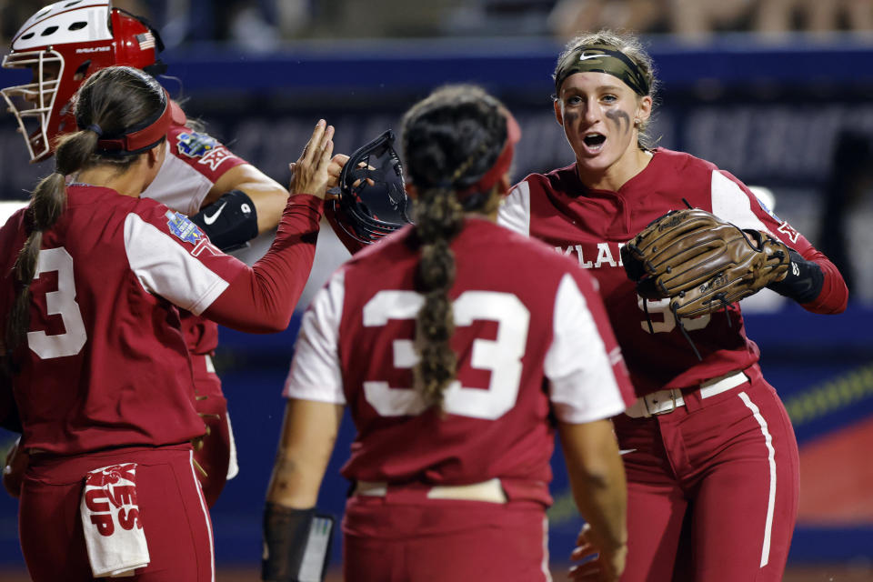 Oklahoma pitcher Jordyn Bahl, right, celebrates with Alyssa Brito (33) and Grace Lyons (3) after a strikeout against Florida State during the third inning of the first game of the NCAA Women's College World Series softball championship series Wednesday, June 7, 2023, in Oklahoma City. (AP Photo/Nate Billings)
