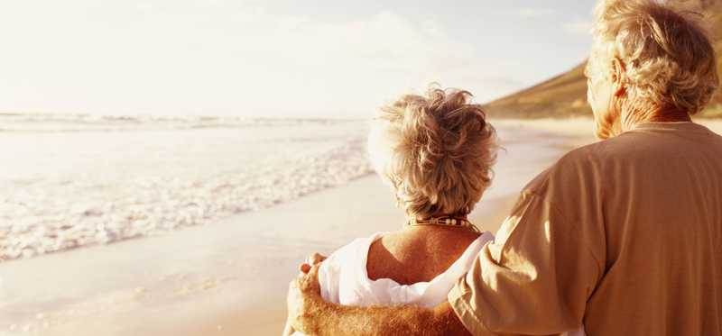 An elderly couple walking on the beach