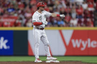 Cincinnati Reds' Kyle Farmer gestures to teammates after hitting a double during the fifth inning of the team's baseball game against the Los Angeles Dodgers in Cincinnati, Friday, Sept. 17, 2021. (AP Photo/Aaron Doster)