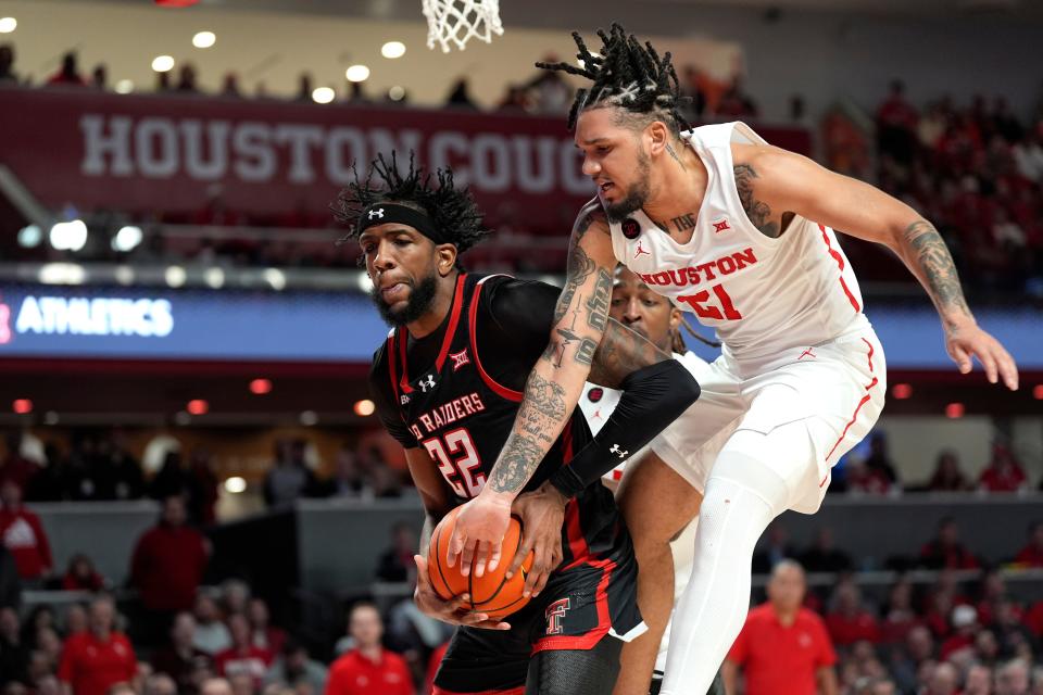 Texas Tech's Warren Washington (22) and Houston's Emanuel Sharp (21) reach for a rebound during the first half of the Big 12 basketball game, Wednesday, Jan. 17, 2024, in Houston.