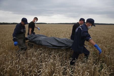 Members of the Ukrainian Emergency Ministry carry a body at the crash site of Malaysia Airlines Flight MH17, near the settlement of Grabovo in the Donetsk region in this July 19, 2014 file photo. REUTERS/Maxim Zmeyev/Files