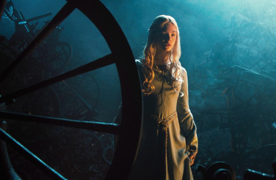 Elle Fanning, as Sleeping Beauty, sees a spindle and walks toward it