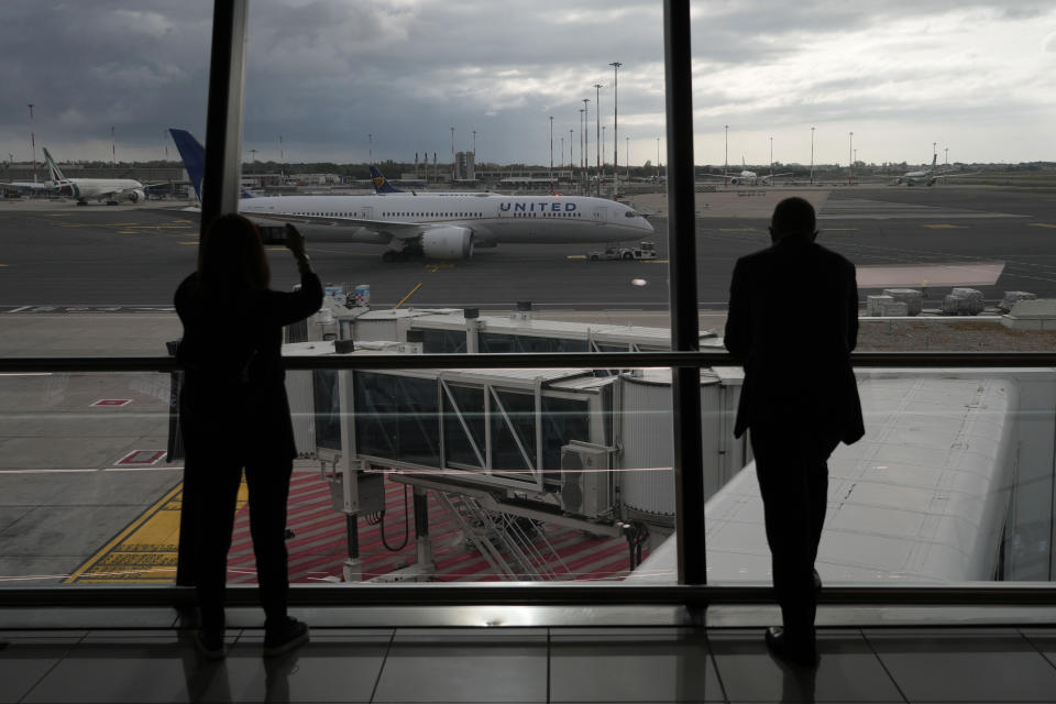 FILE - People look from a window of Fiumicino's Leonardo Da Vinci airport, near Rome, on Nov. 8, 2021. Travelers whose package tours were ruined by the imposition of restrictions to combat the COVID-19 pandemic may be entitled to at least a partial refund, the European Union's highest court said Thursday, Jan. 12, 2023. (AP Photo/Alessandra Tarantino, File)