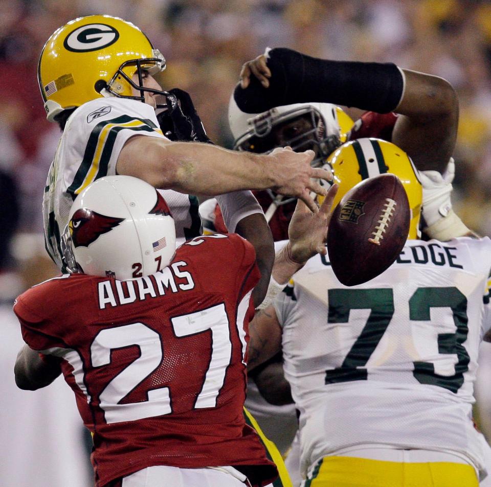 Green Bay Packers quarterback Aaron Rodgers fumbles the ball after being hit by Arizona Cardinals cornerback Michael Adams during overtime of their NFC Wild Card game Sunday, January 10, 2010 at the University of Phoenix Stadium in Glendale, Arizona. The ball was recovered by Cardinals linebacker Karlos Dansby and run 17 yards into the end zone for the game-winning touchdown. The Cardinals won 51-45.