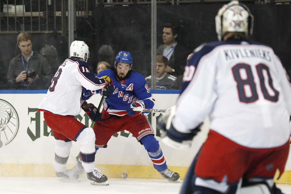 Columbus Blue Jackets center Pierre-Luc Dubois (18) defends New York Rangers center Mika Zibanejad (93) as Columbus Blue Jackets goaltender Matiss Kivlenieks (80) looks on during the second period of an NHL hockey game, Sunday, Jan. 19, 2020, in New York. (AP Photo/Kathy Willens)