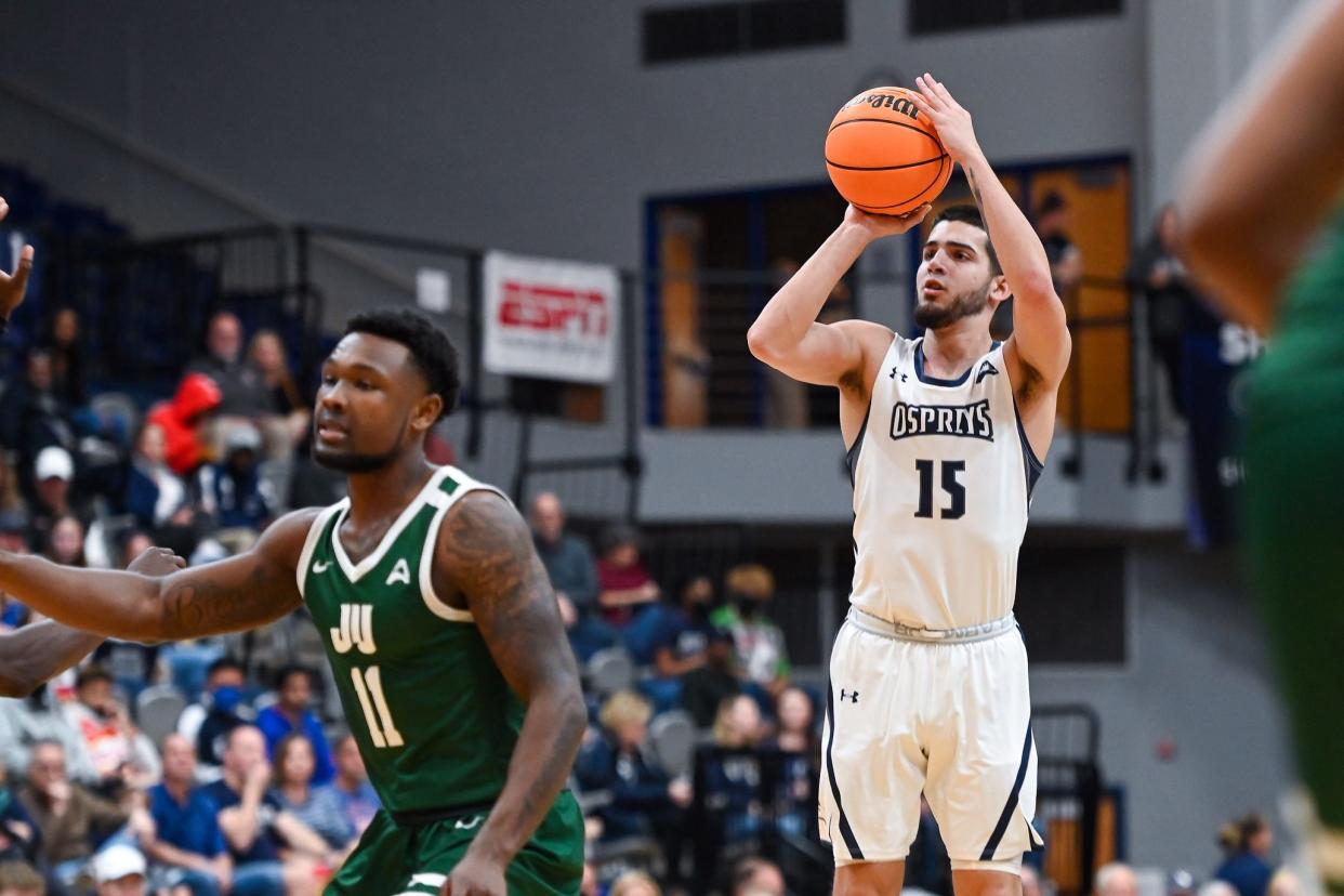 University of North Florida guard Jose Placer (15) attempts a three-point shot against Jacksonville University, but he missed all nine attempts in a 54-51 loss. The Ospreys' inability to make shots behind the arc have been a big factor in UNF's 0-6 start in ASUN Conference play. [Photo by Todd Drexler]