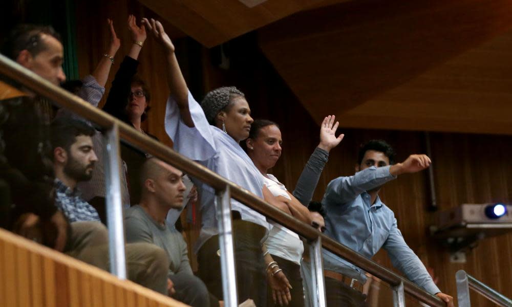 Residents raise their hands in rejection of Kensington and Chelsea Council’s leader Elizabeth Campbell as she speaks during a council meeting to discuss Grenfell Tower.