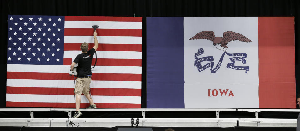 FILE - In this Sept. 14, 2015, file photo, a worker steams wrinkles out of a US flag before the arrival of President Barack Obama at a town hall meeting, at North High School in Des Moines, Iowa. Few states have changed politically with the head-snapping speed of Iowa. (AP Photo/Charlie Neibergall, File)