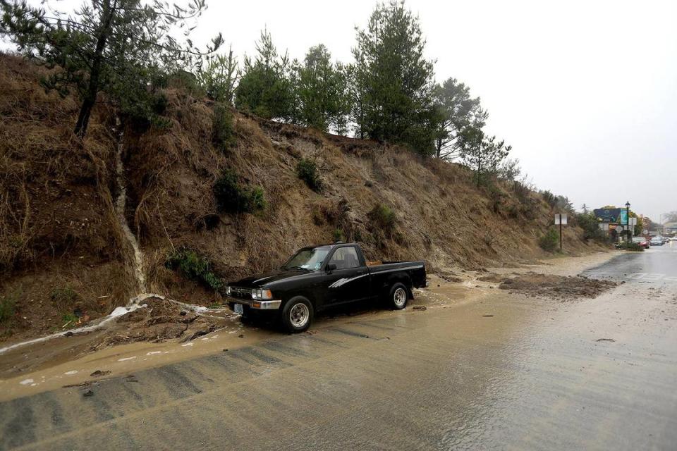 Water and mud flows from a small hillside onto Main Street at Burton Drive in Cambria. A strong storm hit the North Coast area with heavy rain and high winds on Wednesday, Jan. 27, 2021.