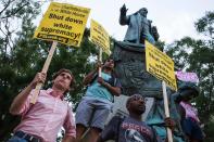 <p>Demonstrators hold signs while standing in front of the statue of Confederate General Albert Pike on August 13, 2017 in Washington, D.C., the only member of the Confederate military with an outdoor statue in the U.S. capital, during a vigil in response to the death of a counter-protestor in the August 12 “Unite the Right” in Charlottesville, Va. (Photo: Zach Gibson/AFP/Getty Images) </p>