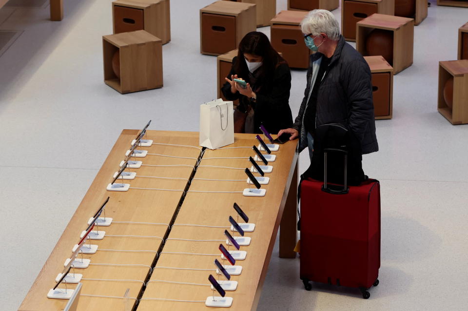 Customers shop for new Apple iPhones at the Apple Store on 5th Avenue shortly after new products went on sale in Manhattan in New York City, New York, U.S., March 18, 2022. REUTERS/Mike Segar