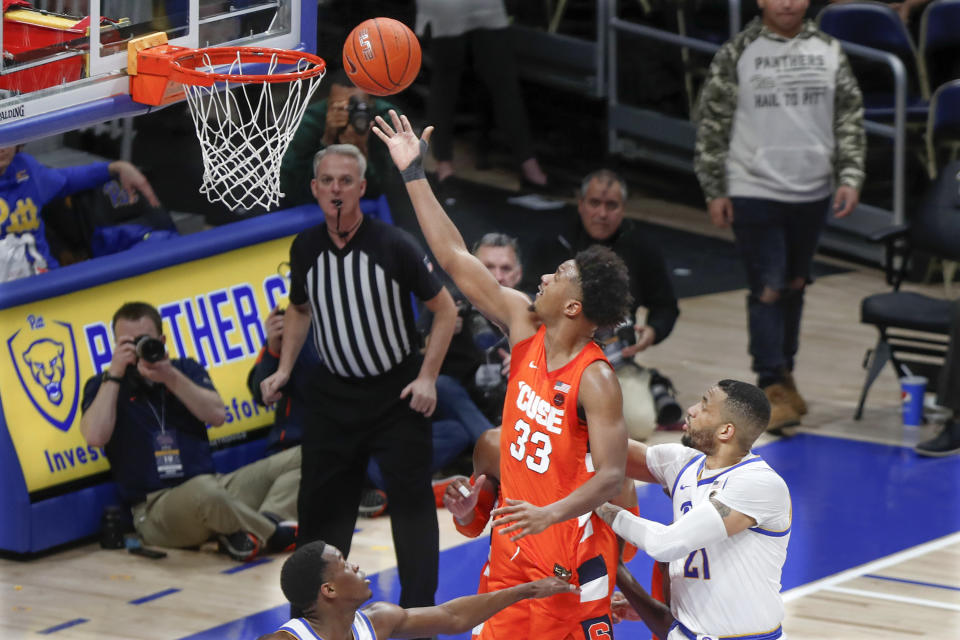 Syracuse's Elijah Hughes (33) scores after getting by Pittsburgh's Terrell Brown (21) during the second half of an NCAA college basketball game, Wednesday, Feb. 26, 2020, in Pittsburgh. (AP Photo/Keith Srakocic)