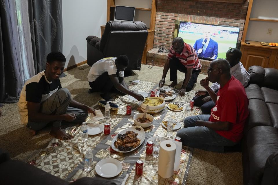 Mauritanians gather for a traditional meal, Friday, July 21, 2023, in Cincinnati. A new surge in migration from Mauritania to the U.S. was made possible by the discovery this year of a new route through Nicaragua, where relaxed entry requirements allow Mauritanians and a handful of other foreign nationals to purchase a low-cost visa without proof of onward travel. (AP Photo/Darron Cummings)