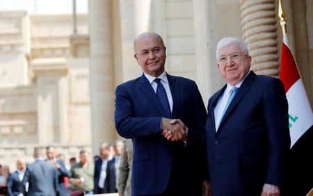 Iraq's outgoing President Fuad Masum (R) and newly elected Barham Salih, shake hands at a ceremony held at Salam Palace in Baghdad, Iraq October 3, 2018. REUTERS/Thaier Al-Sudani