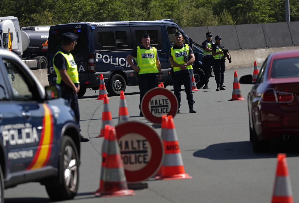 Spanish and French police officers stand guard at the border between Hendaye and Irun to monitor protestors against the G-7 summit in nearby Biarritz, France Friday, Aug. 23, 2019. (AP Photo/Emilio Morenatti)