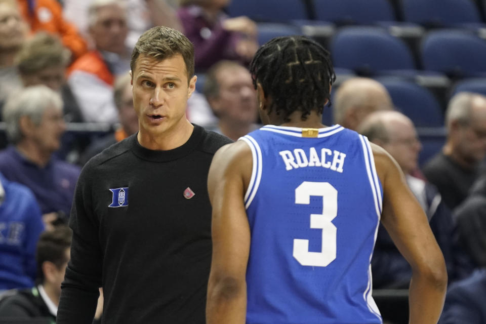 Duke head coach Jon Scheyer, left, talks with Jeremy Roach (3) during the first half of an NCAA college basketball game against Miami at the Atlantic Coast Conference Tournament in Greensboro, N.C., Friday, March 10, 2023. (AP Photo/Chuck Burton)