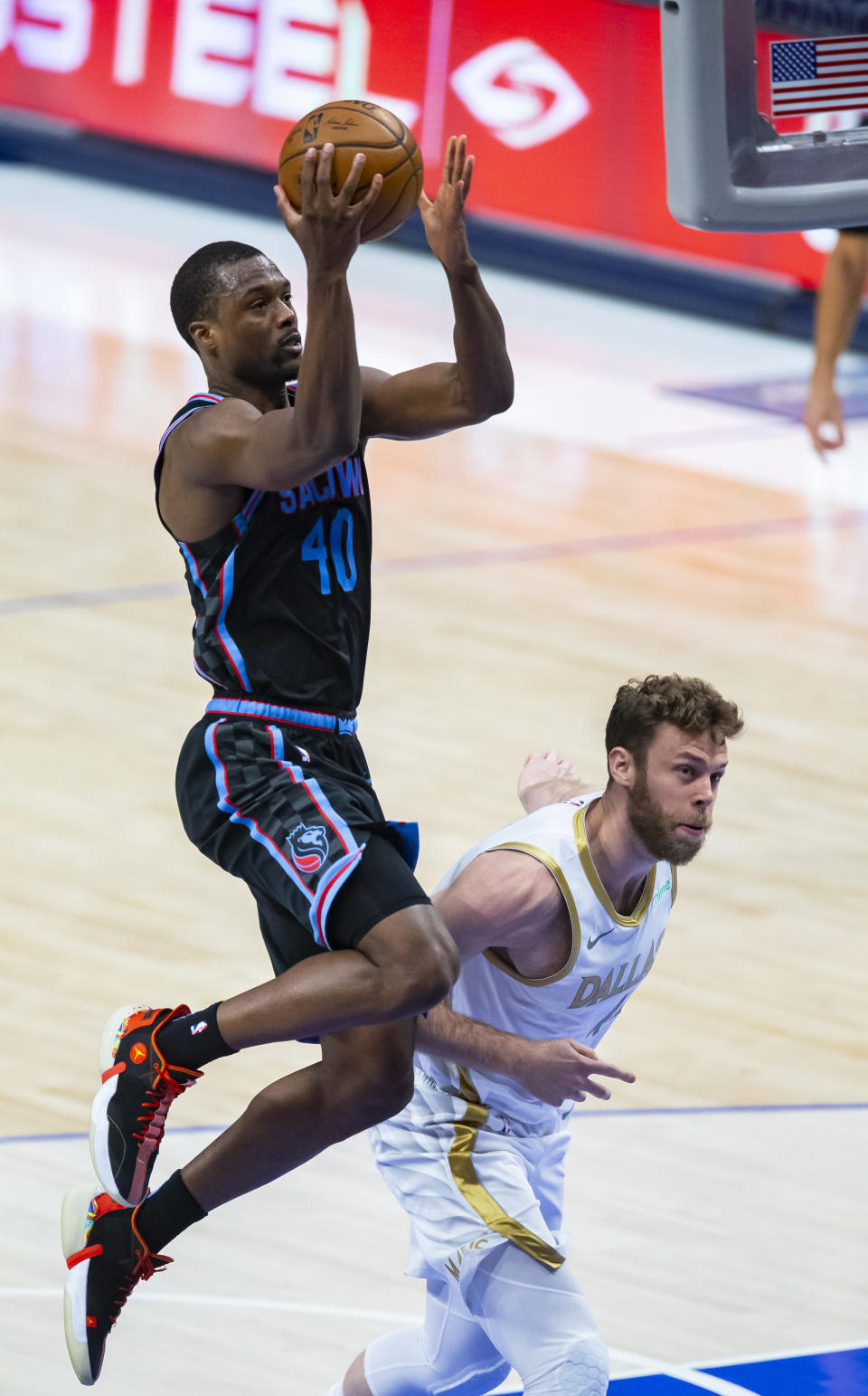 Sacramento Kings forward Harrison Barnes (40) attempts to shoot as Dallas Mavericks forward Nicolo Melli (44) defends during the second half of an NBA basketball game, Sunday, April 18, 2021, in Dallas. (AP Photo/Brandon Wade)