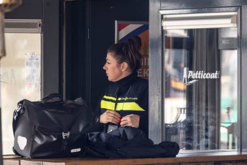 A policewoman stands at the entrance to the "Petticoat" cafe while evidence is secured inside the building. In a hostage-taking that ended without bloodshed, four people were threatened with knives by a perpetrator known to the police. Christoph Reichwein/dpa