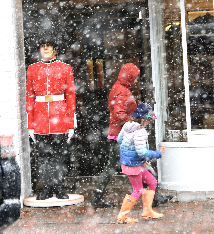 People pass by the new Best of British store in Portsmouth's Market Square during the winter storm Tuesday, March 14, 2023.