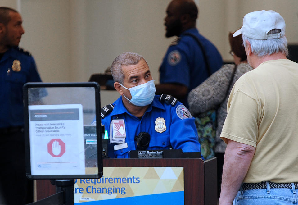 A TSA officer wears a protective mask while screening travellers at Orlando International Airport. (Paul Hennessy/Echoes Wire/Barcroft Media via Getty Images)