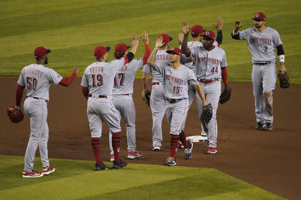 The Cincinnati Reds celebrate after a baseball game against the Arizona Diamondbacks, Friday, April 9, 2021, in Phoenix. The Reds won 6-5 in 10 innings. AP Photo/Matt York)